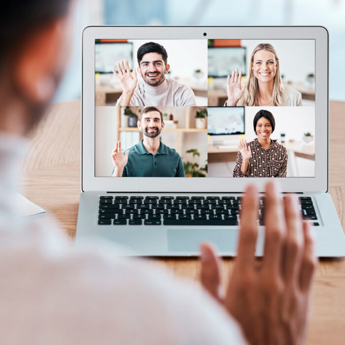 Team, laptop and video call for webinar, online meeting and communication together. Digital device, teamwork and coworkers have discussion, conference or wave with smile, planning or happy with sales.