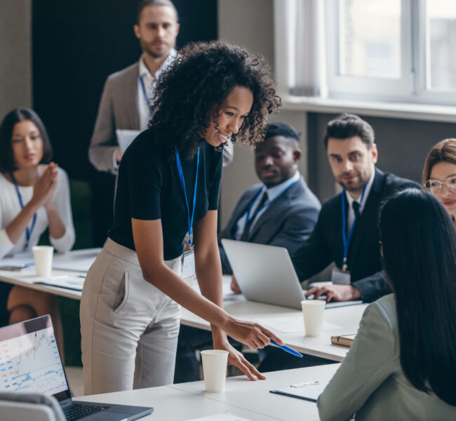Smiling African female business trainer talking to audience during a conference in convention center Smiling African female business trainer talking to audience during a conference in convention center