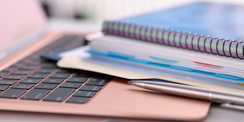 Pen and documents are on the keyboard Pen and documents are on the keyboard. Online learning concept