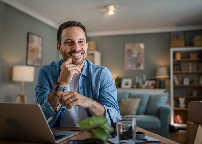 one man adult caucasian work on laptop at home happy smile one man adult caucasian male with beard work on his laptop computer at home happy smile success freelance entrepreneur or remote work concept